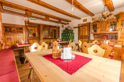 a dining room with a wooden table and chairs at Alpengasthof Enzianhof in Zell am Ziller