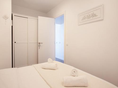 バルセロナにあるStay U-nique Apartments Sant Pauの白いベッドルーム(ベッドにタオル2枚付)