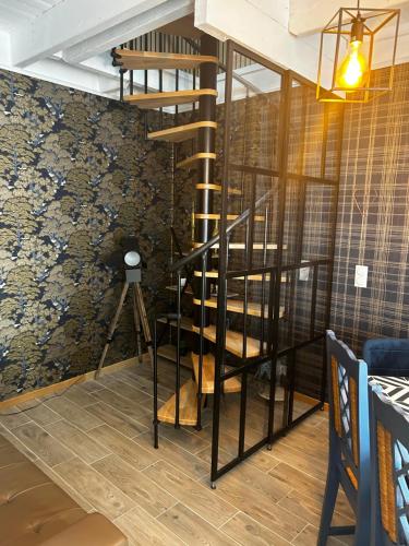 a spiral staircase in a room with a wall at Gîtes le Mont Desclos Saint Michel in Beauvoir