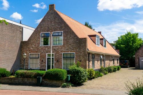 a brick house with a pitched roof at Boerderie De Gouden Leeuw in Voorschoten