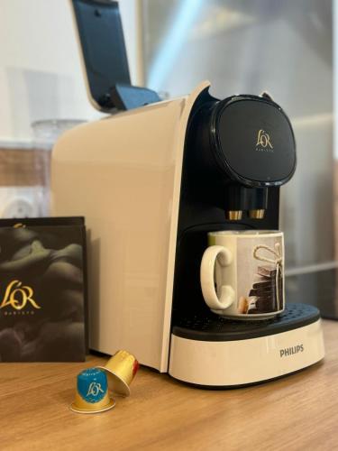 a coffee maker sitting on a table with a coffee cup at Le Perchoir de Linas in Linas