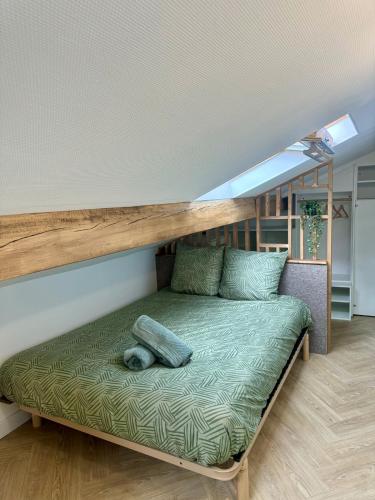 a bed in a small room with a wooden shelf at Le Perchoir de Linas in Linas