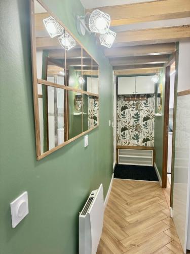 a hallway with green walls and a mirror at Le Perchoir de Linas in Linas