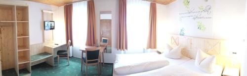 Schlafzimmer mit einem Bett, einem Schreibtisch und einem Fenster in der Unterkunft Gasthaus Zur Ölmühle in Oberderdingen