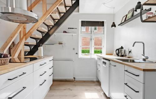 a kitchen with white cabinets and a staircase at 3 Bedroom Lovely Home In Ulfborg in Ulfborg