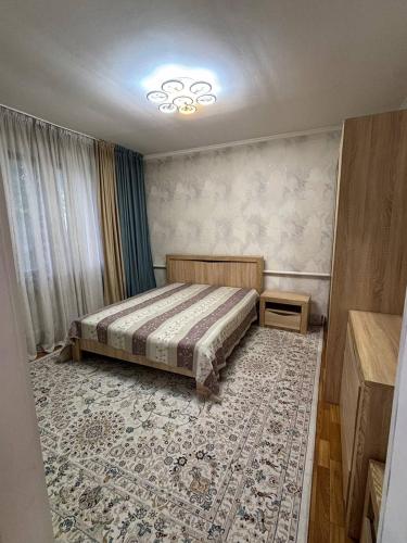 a bedroom with a bed and a rug at Гостевой дом Altyn Dan in Kegen