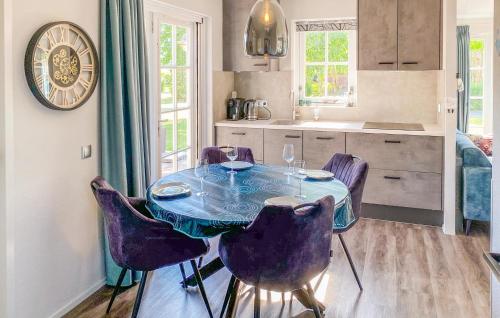 a dining room table with purple chairs in a kitchen at Cozy Home In Hoge Hexel With Sauna in Hoge-Hexel