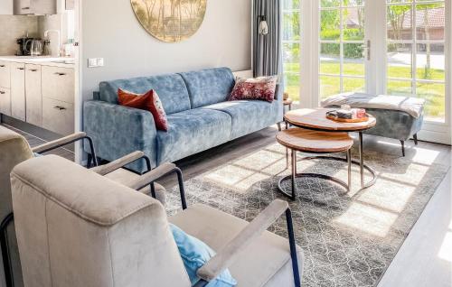 a living room with a blue couch and a table at Cozy Home In Hoge Hexel With Sauna in Hoge-Hexel