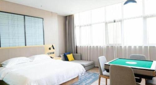 a bedroom with a bed and a desk with a pool table at Echarm Hotel Xiangyang Erqi in Xiangyang