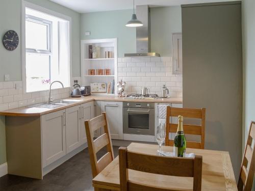a kitchen with a table with a bottle of wine at Rockhill in Inverness