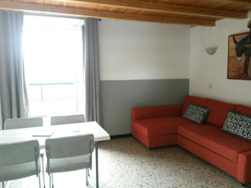 a living room with a red couch and a table at Agriturismo OlivArancio in Leivi