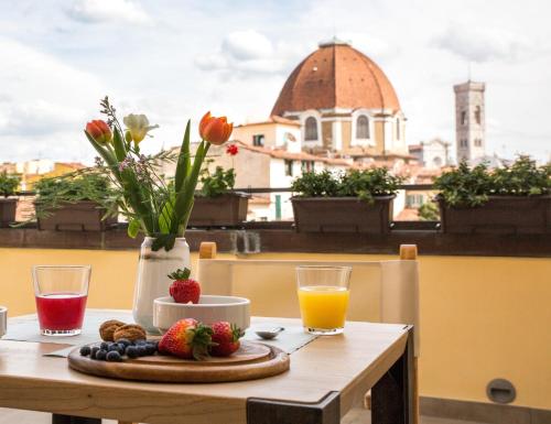 a table with fruit and juice and a view of a city at Relais Luce Florence in Florence