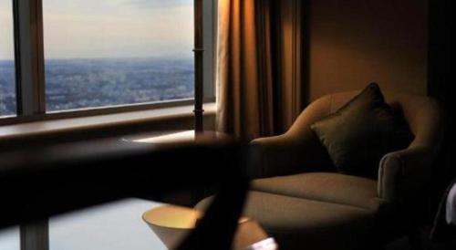 a living room with a couch and a large window at Yokohama Royal Park Hotel in Yokohama