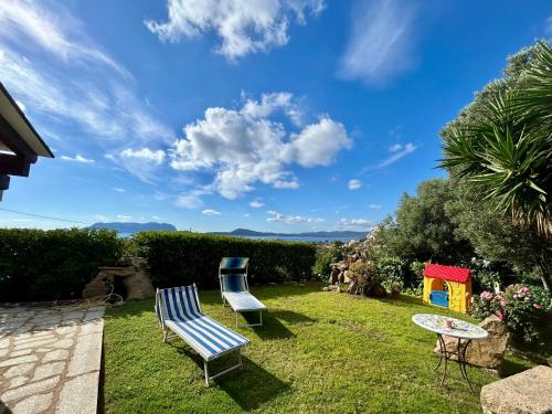 two blue chairs and a table in a yard at Bellavista Vacation in Olbia