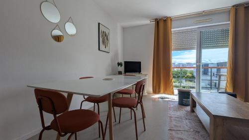 une salle à manger avec une table et des chaises et une fenêtre dans l'établissement T3 - Les Minimes - Entre plage et Vieux-Port, à La Rochelle