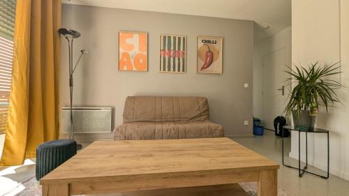 un salon avec un canapé et une table en bois dans l'établissement T3 - Les Minimes - Entre plage et Vieux-Port, à La Rochelle