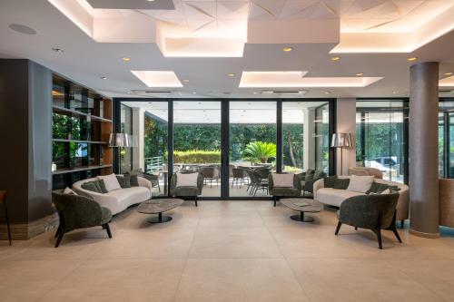 a waiting room with chairs and tables and windows at Hotel Ivka in Dubrovnik