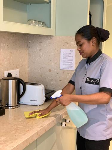 a woman standing in a kitchen preparing food at Theory9 Premium Service Apartments Bandra in Mumbai