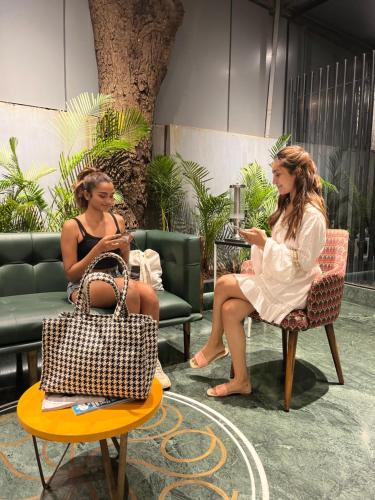 two women are sitting in chairs in a store at Theory9 Premium Service Apartments Bandra in Mumbai