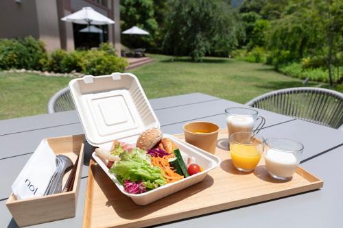 a tray of food on a table with a salad and orange juice at nol hakone myojindai in Hakone