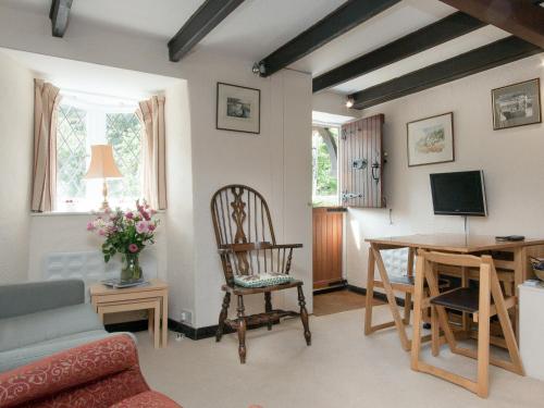 ein Wohnzimmer mit einem Tisch, einem Stuhl und einem Schreibtisch in der Unterkunft Cobbles in Salcombe