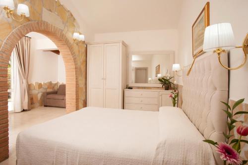 a bedroom with a white bed in a room at Fattoria Maremmana in Marina di Grosseto