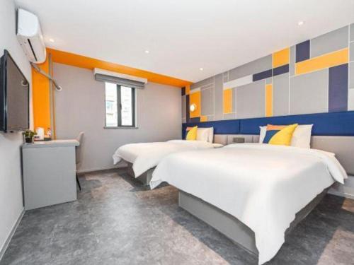 a hotel room with two beds and a television at 7 Days Inn Nanjing Xinjiekou Changfu Street Metro Station in Nanjing