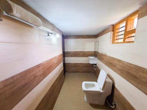 a bathroom with a toilet and a window at Viewpointwayanad in Mananthavady