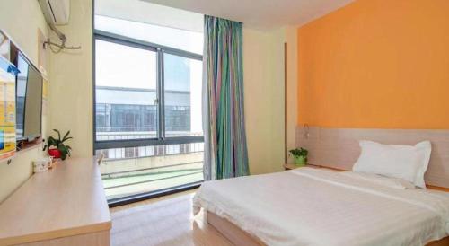 a bedroom with a bed and a large window at 7 Days Inn Suzhou Wangting Pearl Commercial Plaza in Suzhou