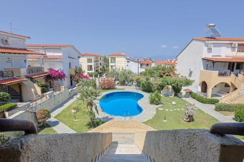 a swimming pool in the middle of a yard with buildings at Veranda Seaview Residence in Pefkochori