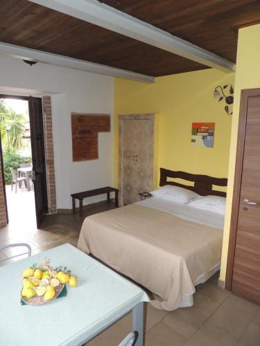 a bedroom with a bed and a table with a bowl of fruit at All'Ombra Del Noce B&B in Catona