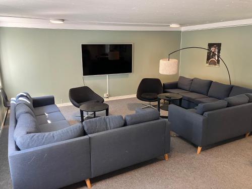 a living room with couches and chairs and a flat screen tv at Nordsjögården in Järvsö