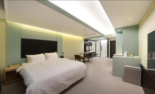 a bedroom with a large white bed and a table at Nine Tree Drive in Hotel in Gunsan
