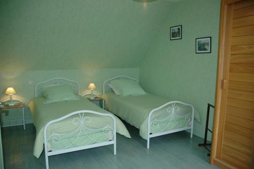 LézardrieuxにあるGîte de Kervoasの緑の壁のベッドルーム(ベッド2台付)