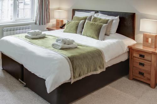 a bedroom with a large bed with two towels on it at Stocks Hotel in Sark