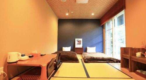 a room with two beds and a desk in it at Fuji Shoei kaikan in Fuji