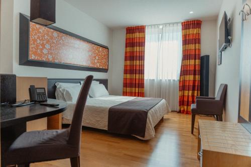 a hotel room with a bed and a desk and chairs at Sanlu Hotel in Serrano