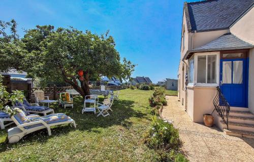 a yard with chairs and a house with a tree at 3 Bedroom Amazing Home In Plouhinec in Plouhinec