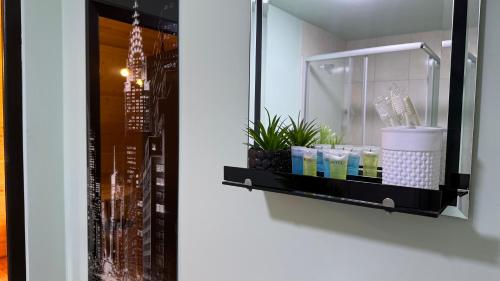 a shelf on a wall with cosmetics and a mirror at Oda Riverside Cottages in Aragvispiri