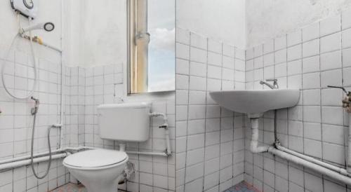 a bathroom with a toilet and a sink at OYO 89706 To-day Hotel in Sibu