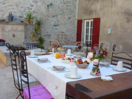 a table with a white table cloth with food on it at Chateau de la Rode in Aumessas