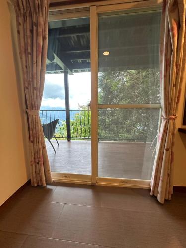 a large glass door with a view of a balcony at Cingjing Four Seasons B&B in Renai