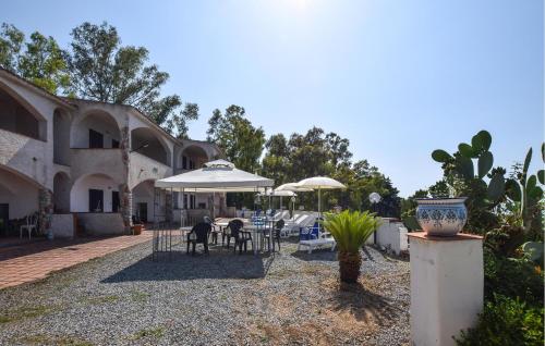 eine Terrasse mit Tischen und Sonnenschirmen vor einem Gebäude in der Unterkunft 2 Bedroom Lovely Apartment In Parghelia in Parghelia