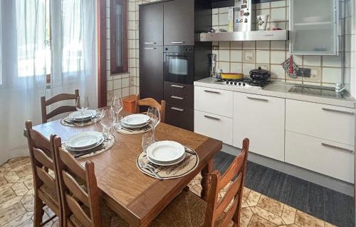 a kitchen with a wooden table with plates and wine glasses at Lovely Apartment In Collesalvetti in Collesalvetti