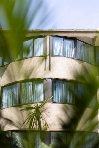 a building with a palm tree in front of it at Cézanne Hôtel in Cannes