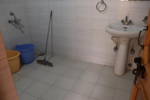 a bathroom with a sink and a shower with a mop at Nilza Guest House in Leh