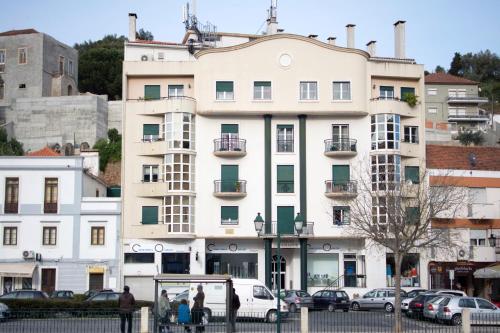 a white building with cars parked in front of it at AL embaixador in Alenquer