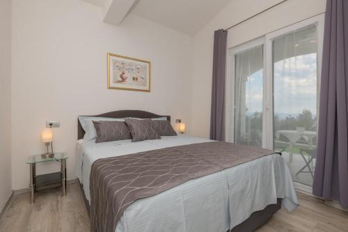 a bedroom with a large bed and a large window at Villa Miramel mit privaten Swimmingoool - Makarska Exklusiv in Makarska