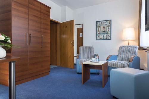 a hospital room with two chairs and a table at Hotel Seeschwalbe in Cuxhaven