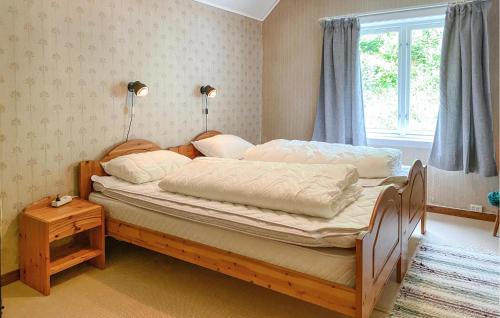 a bedroom with a bed with two lamps and a window at Awesome Home In Åheim With Wifi in Åheim